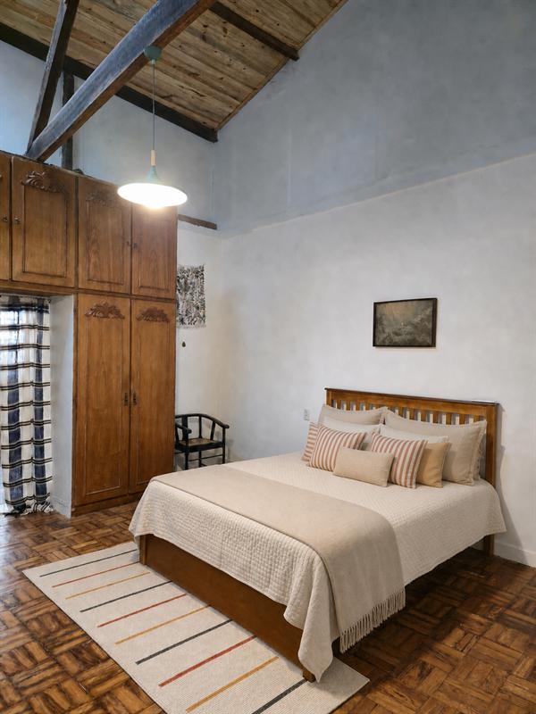 Quarto do Apartamento 2 com cama queen, piso de taco e armário de madeira